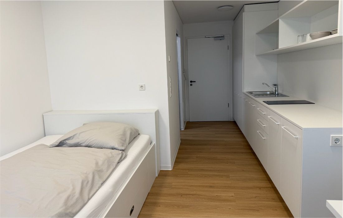 Single apartment with bed, kitchenette and hallway